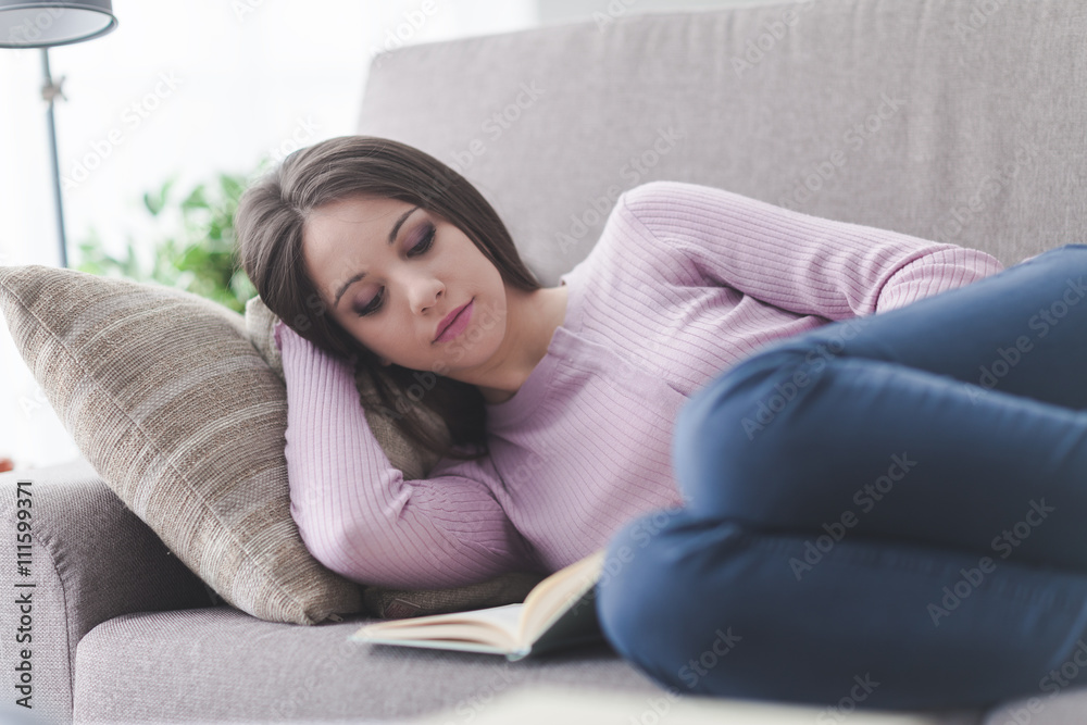 Girl reading a book on the sofa Girl reading a book on the sofa