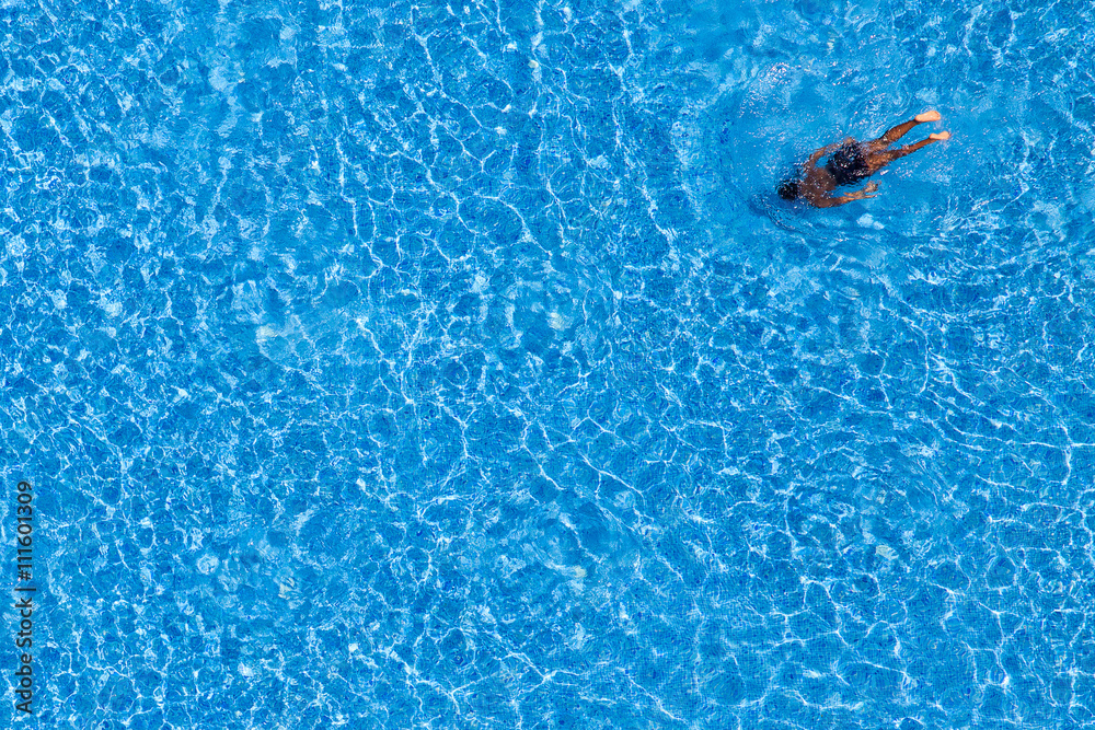 Man swim in the pool at the hotel. View from above.
