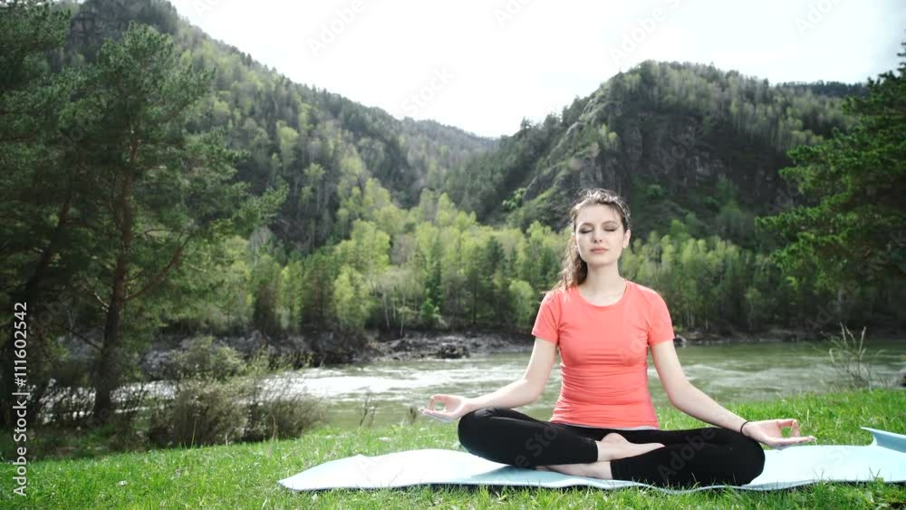 Practicing yoga in the morning, mountains and sun ray in the background. Practicing yoga in the morning, mountains and sun ray in the background.
