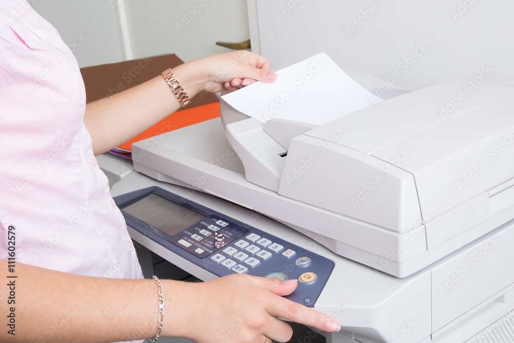 Close up of a young secretary using a copy machine Close up of a young secretary using a copy machine