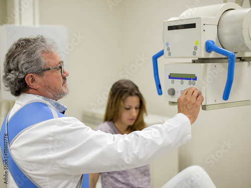Adult doctor with patient on x-ray machine