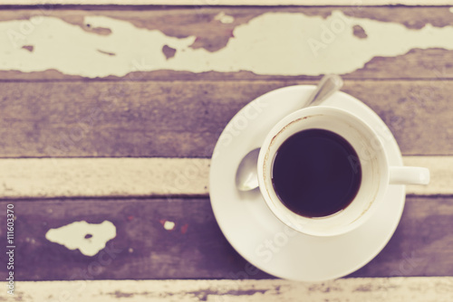 top view of coffee cup on grunge wooden table in vintage style photo