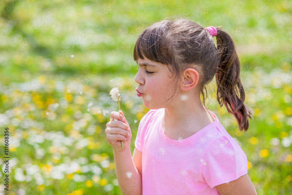 Child blowing dandelion