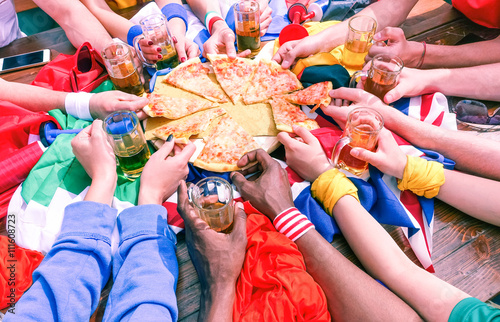 Many hands sharing pizza view from above - Multicultural sport fans arms on party table  at cafe bar eating and drinking together - Concept of international friendship and fun