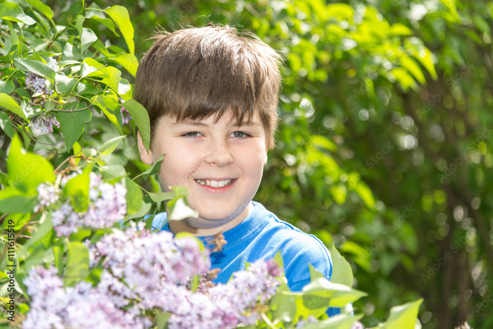 Portrait of boy in park with blooming lilacs Portrait of boy in park with blooming lilacs