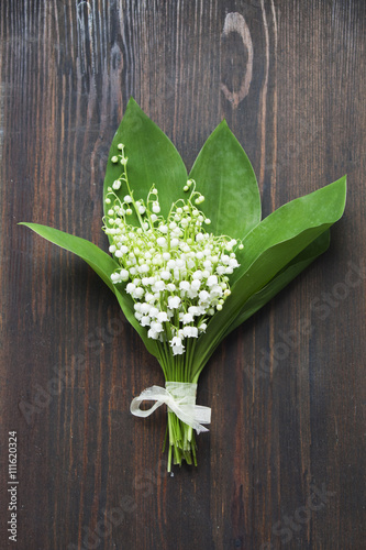 Fototapeta Naklejka Na Ścianę i Meble -  lilies of the valley bouquet  on dark wooden background