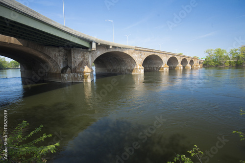 Arches of the Bulkeley Bridge connect Hartford and East Hartford across the Connecticut River on a sunny spring day.