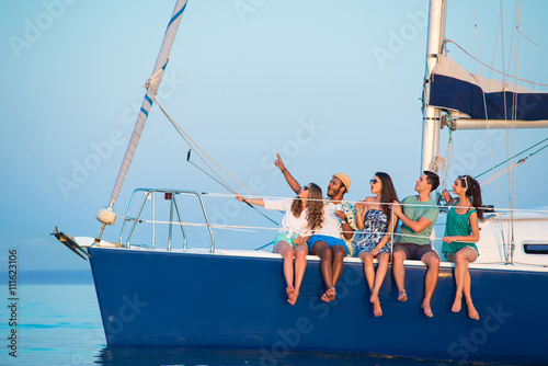 People take selfies on yacht. Girls and guys on boat. One more photograph. Send greetings to the relatives.