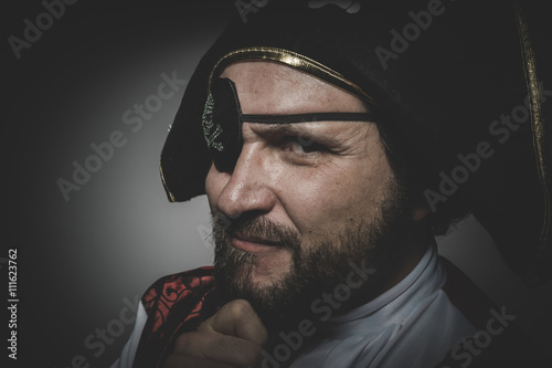 Fototapeta Sexy man pirate with eye patch and old hat with funny faces and
