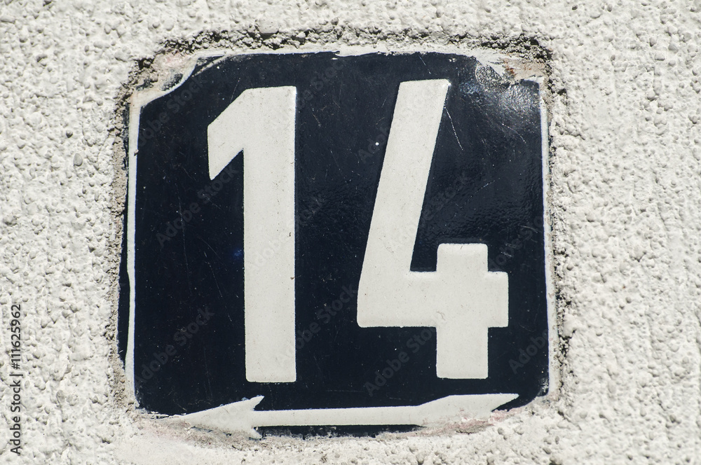 Weathered grunge square metal enameled plate of number of street address with number 14 closeup