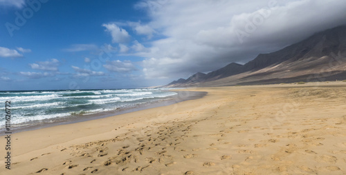 Endless sandy beach with turquoise ocean.