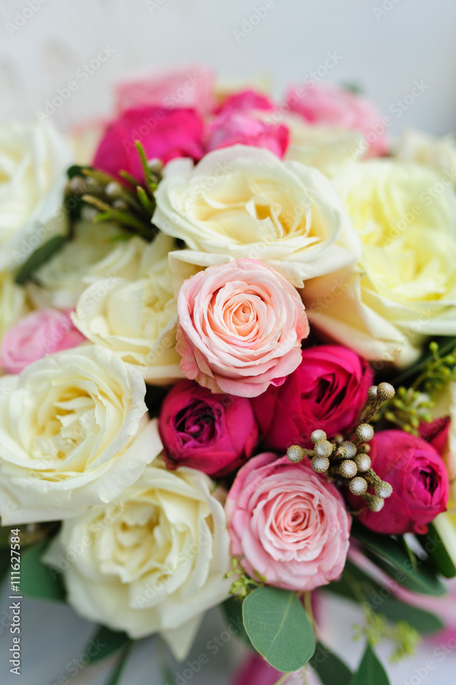 Beauty of colored flowers. Bridal accessories. Close-up bunch of florets. Details for marriage and for married couple. Wedding bouquet with peonies, roses on the white background