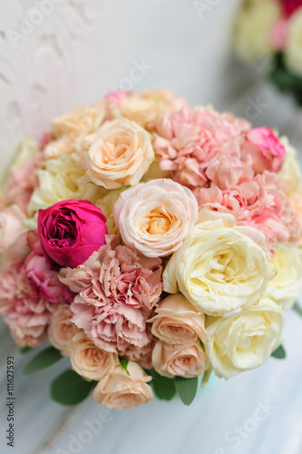 Beauty of colored flowers. Bridal accessories. Close-up bunch of florets. Details for marriage and for married couple. Wedding bouquet with peonies, roses on the white background