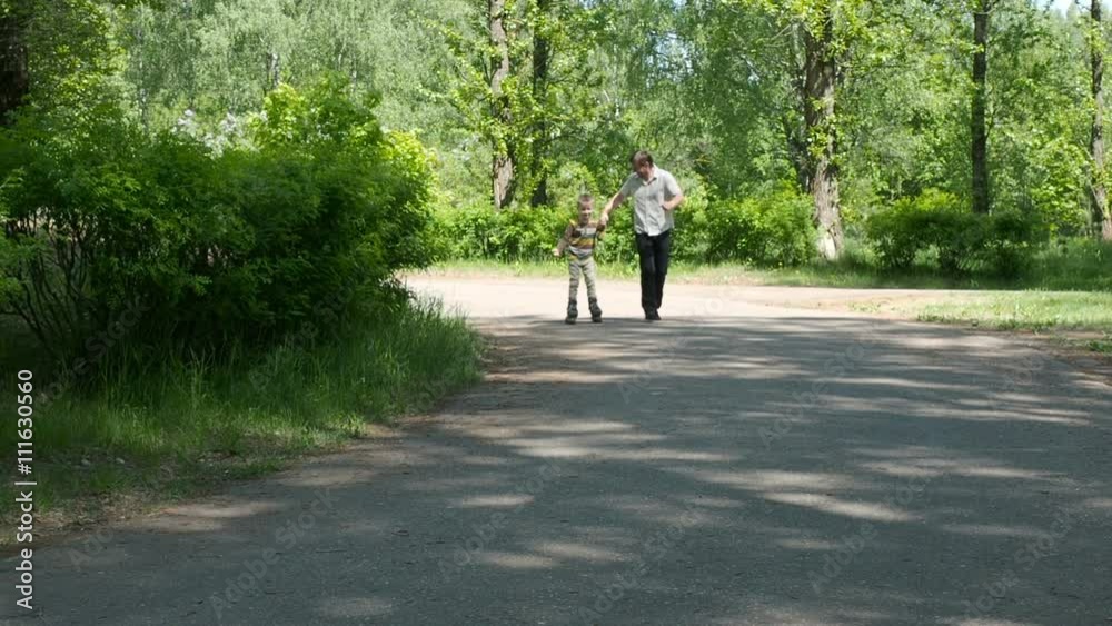 Father learning his son to ride on roller skates Father learning his son to ride on roller skates