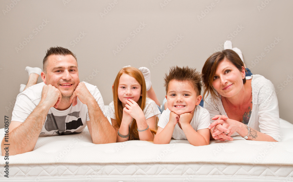 Smiling family having fun lying on the bed Smiling family having fun lying on the bed