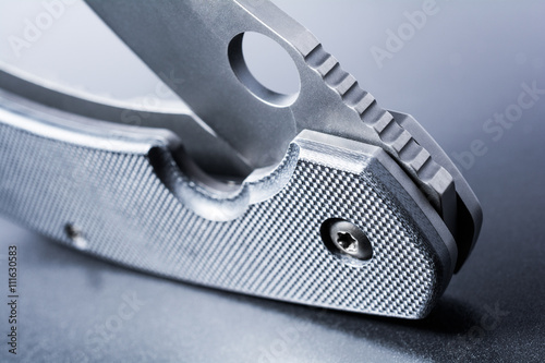 Close Up Of A Standing Half Opened Faint Military Knife On Dark Ground photo