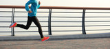 young fitness woman runner running on seaside road