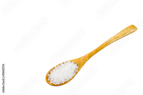 white crystals sea salt on wooden spoon on white background, top view
