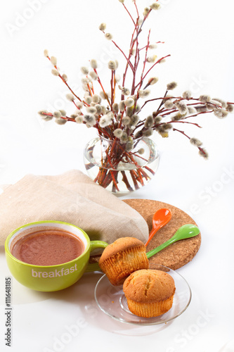 Breakfast: a cocoa cup, biscuits, willow branches in a vase