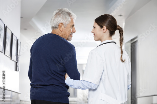 Female Doctor Holding Senior Man s Arm In Rehab Center