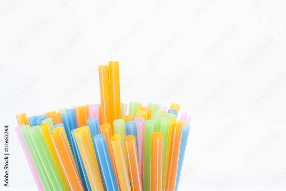 Fototapeta premium Colorful plastic straws used for drinking water or juices on whi