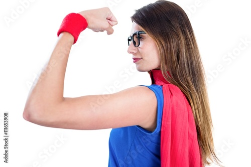 Woman in superhero costume while flexing muscles