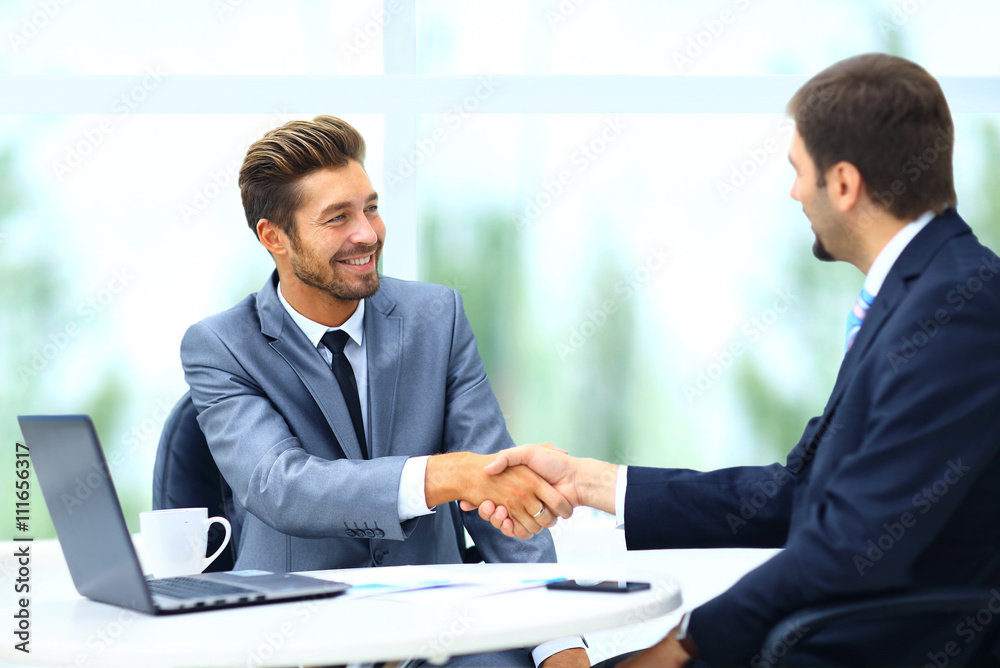 Two business colleagues shaking hands during meeting Two business colleagues shaking hands during meeting