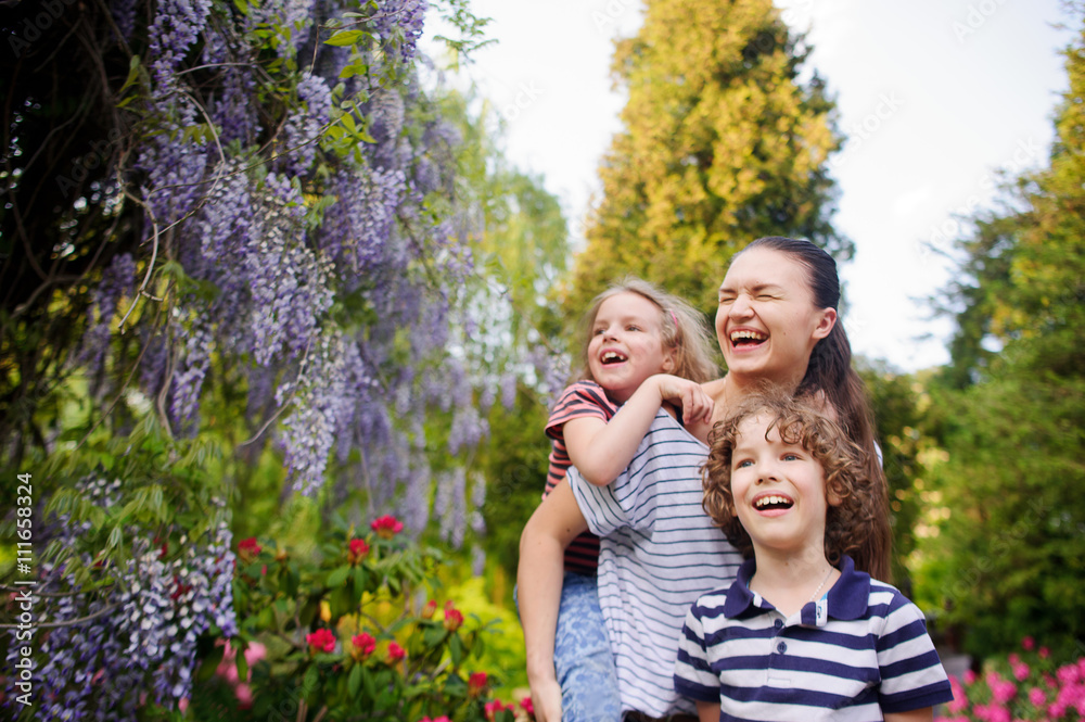 Fototapeta premium Young woman with two children walk the park