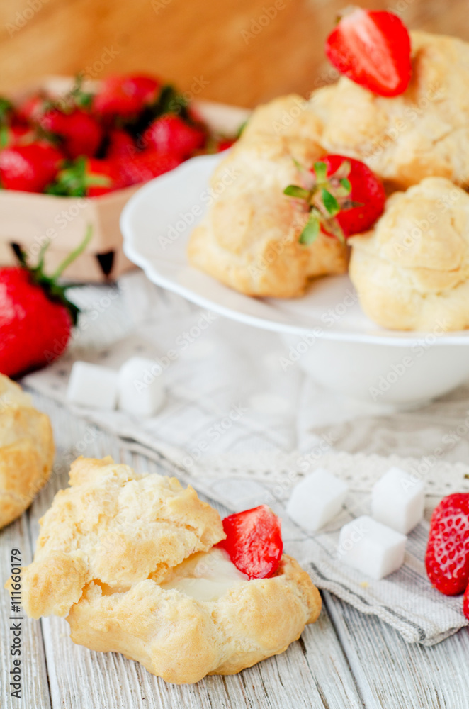 dessert with berries , custard eclairs or cakes with cream and red strawberries on a wooden background
dessert with berries , custard eclairs or cakes with cream and red strawberries on a wooden background