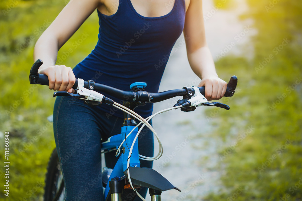 Woman mountain biking and holding handlebars Woman mountain biking and holding handlebars