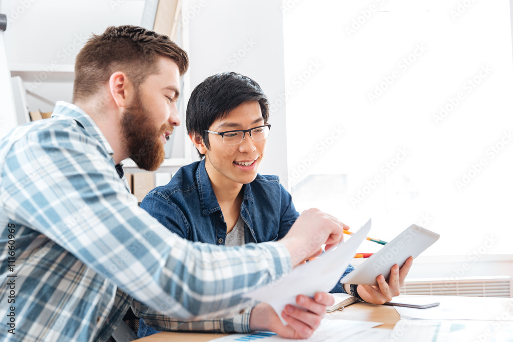 Fototapeta premium Two businessmen making business plan and using tablet