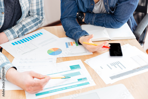 Top view of two businesspeople working at table in office