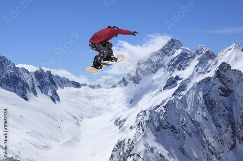 Snowboard rider jumping on mountains. Extreme snowboard freeride sport.