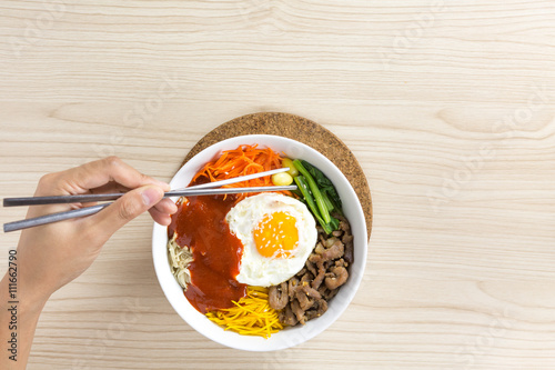 pouring sause to bibimbap , korean dish