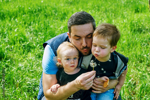father and sons relationship, playing with dandelions in the Park