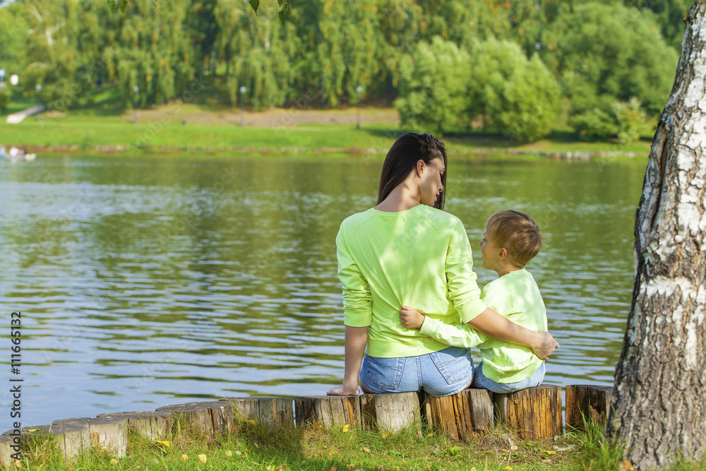 Fototapeta premium Young Mother and son playing in summer park
