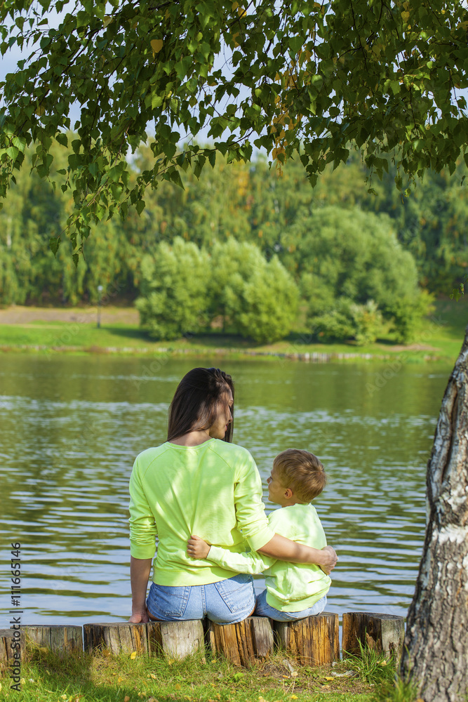 Young Mother and son playing in summer park Young Mother and son playing in summer park