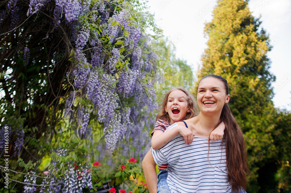 Mother and daughter walking in the summer park Mother and daughter walking in the summer park