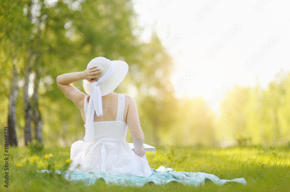 Naklejka premium Young woman reading a book in the Park.