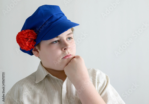 Portrait of aboy teenager in Russian national cap with cloves photo