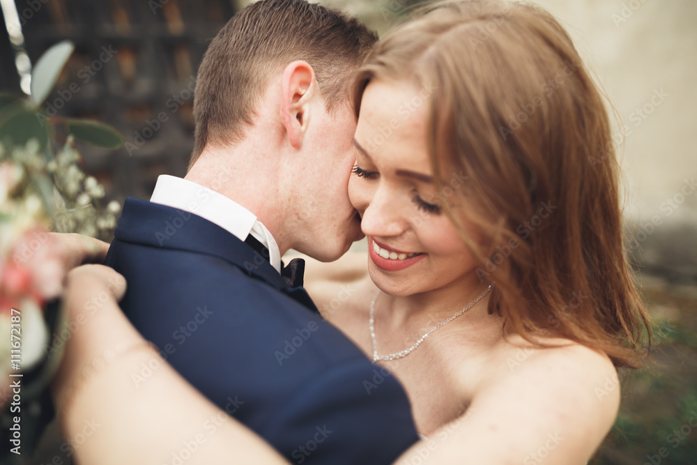 Happy wedding couple hugging and smiling each other on background old castle Happy wedding couple hugging and smiling each other on background old castle