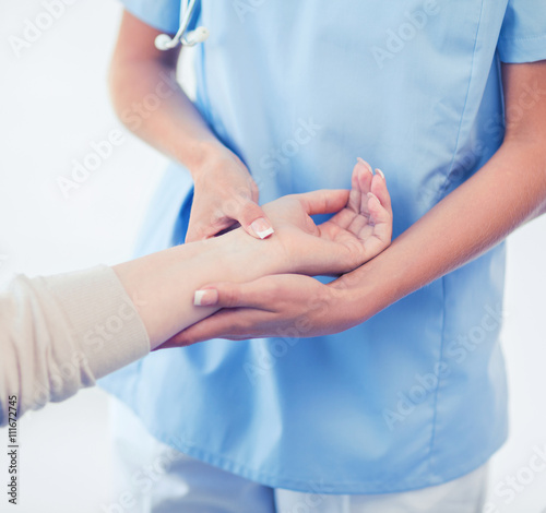 nurse with patient measuring pulse