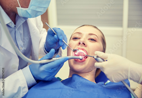 close up of dentist treating female patient teeth