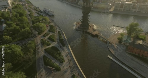 Aerial view of Peter the Great Statue on a summer spring day at sunset. Crowds of people walking along the park near river.  