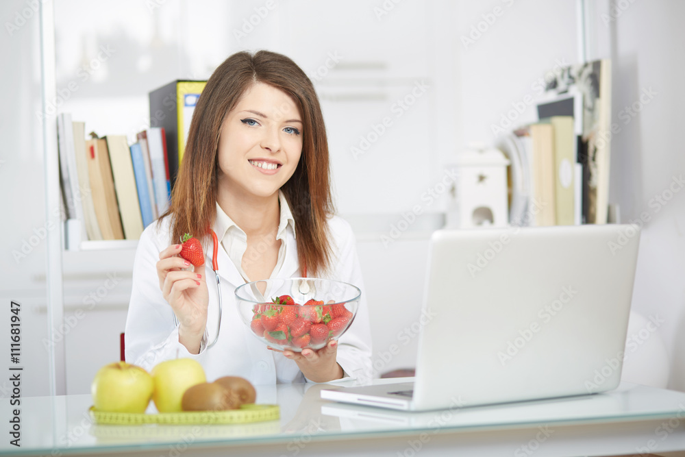 young nutritionist showing strawberries