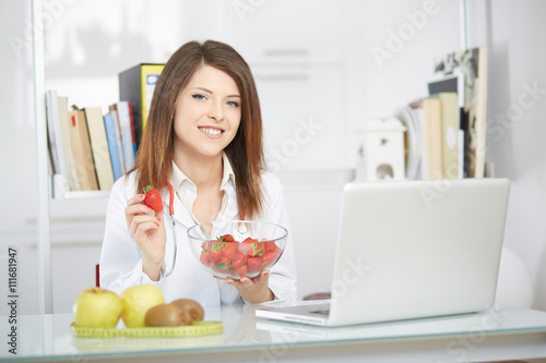 young nutritionist showing strawberries