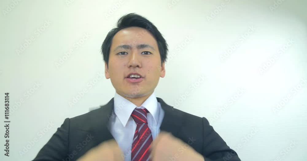 Japanese business man getting dressed and setting hair in mirror Japanese business man getting dressed and setting hair in mirror