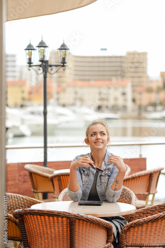 Joyful happy smiling pretty female in restaurant on luxury marina background. 