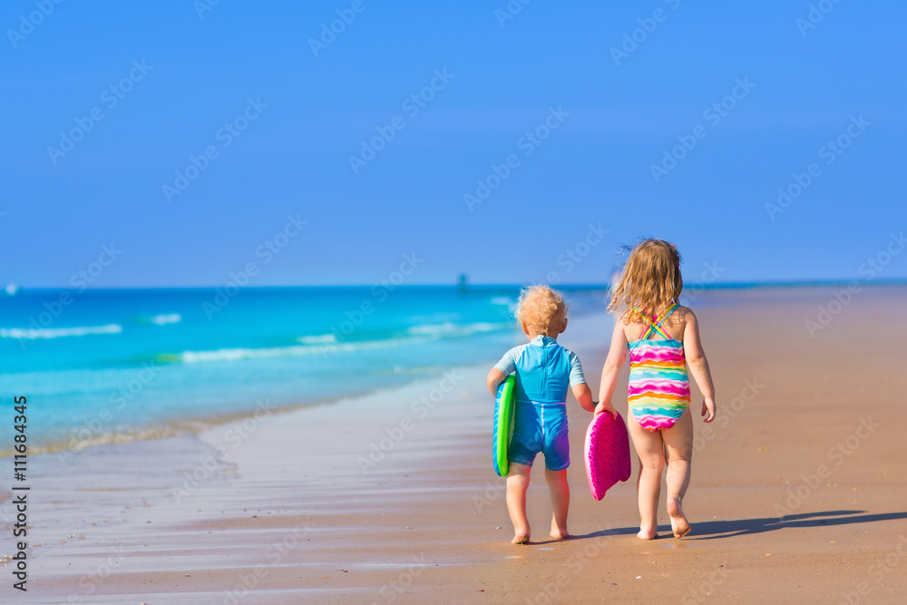 Children with surf boards on tropical beach Children with surf boards on tropical beach