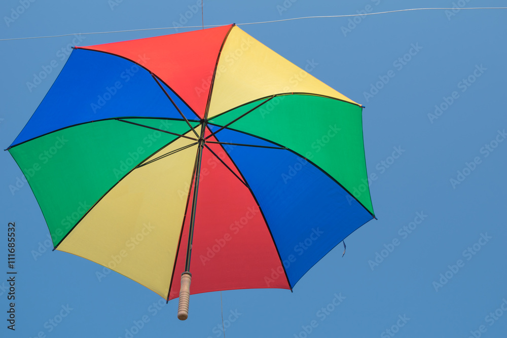Colorful umbrella is hanging in blue sky